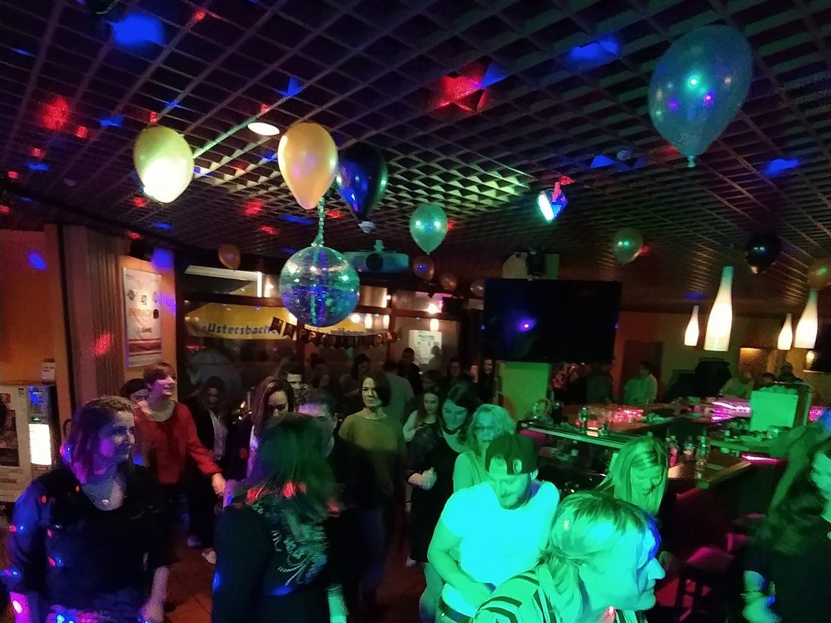 Gäste feiern gemeinsam auf einer Geburtstagsparty in Augsburg mit Discokugel und Ballons