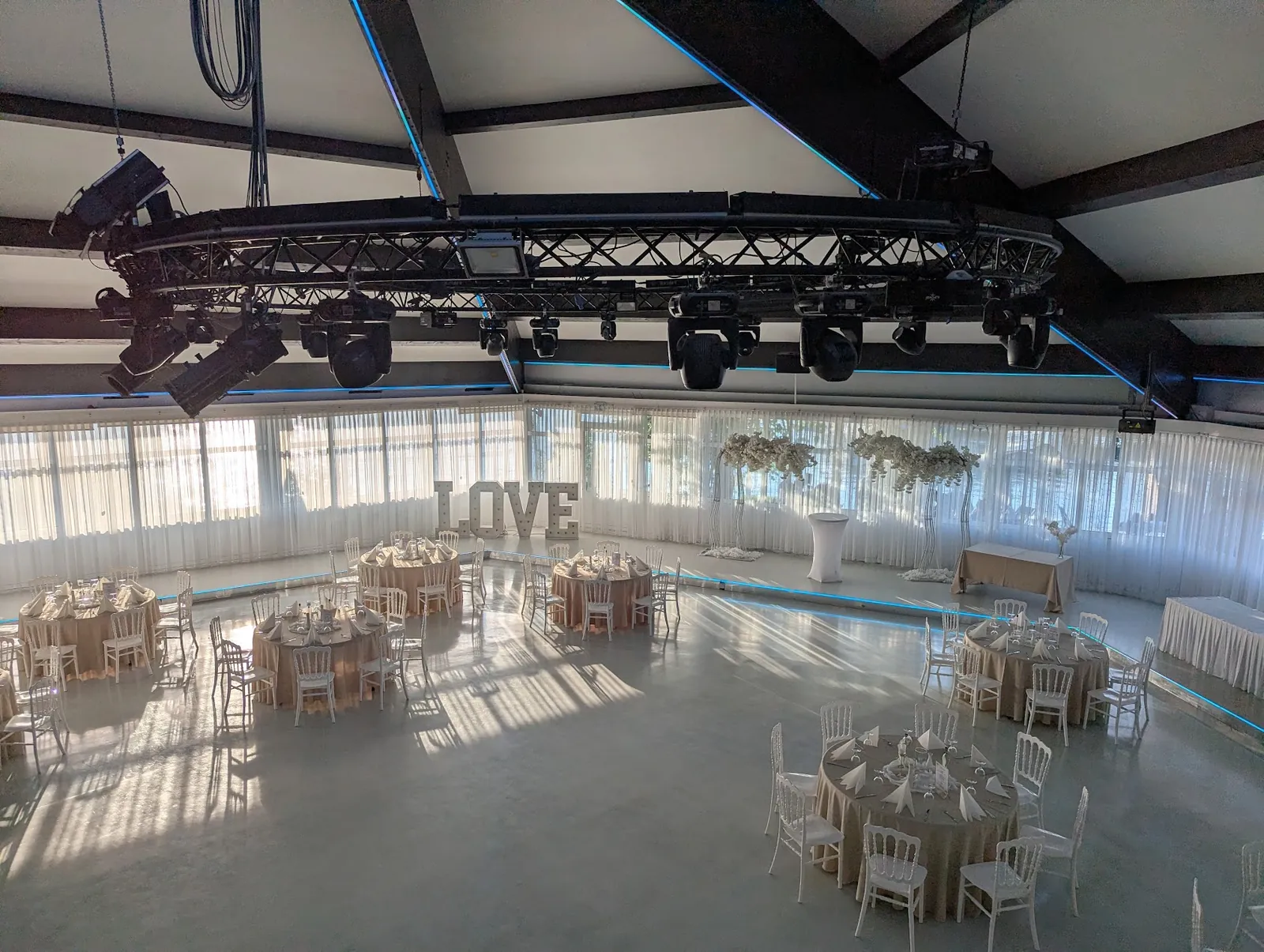 Saal im Royal am See in Friedberg mit fest verbauter Traverse, Moving Heads und eingedeckten Tischen vor der Hochzeit