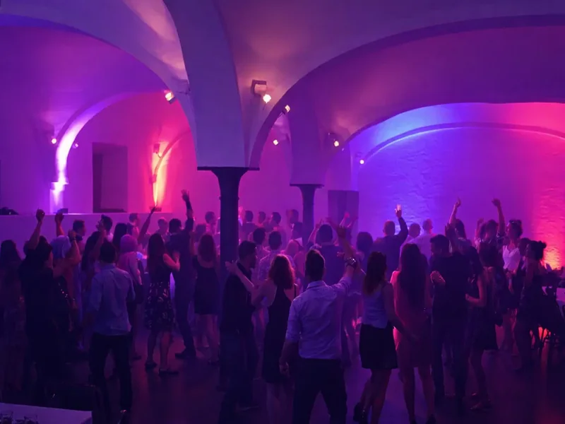 Innenraum des Gut Schwabhof mit farbiger Ambientebeleuchtung bei der Firmenfeier