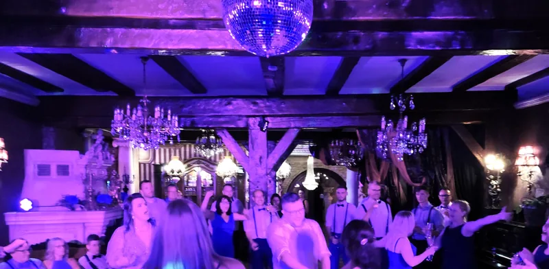 Tanzfläche mit Discokugel und violettem Licht bei einer Feier