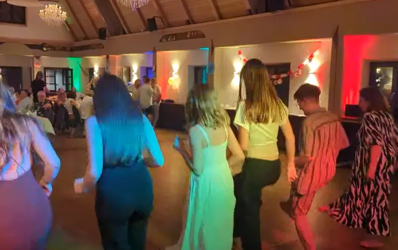 Gäste tanzen im Saal des Strasser Gersthofen, an den Wänden bunte Beleuchtung und eine Geburtstagsgirlande