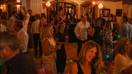 Volle Tanzfläche im holzgetäfelten Saal mit DJ, DJ für Geburtstag