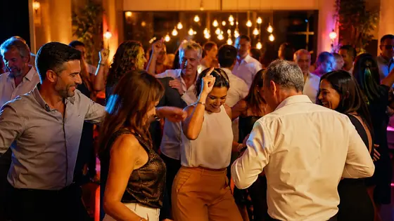 Tanzgruppe vor warmer Edison-Bulb-Lichtwand, DJ für Geburtstag
