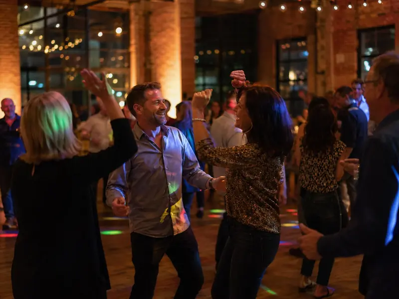Tanzende Paare in einer Industrieloft-Halle mit Backstein, DJ für Geburtstag