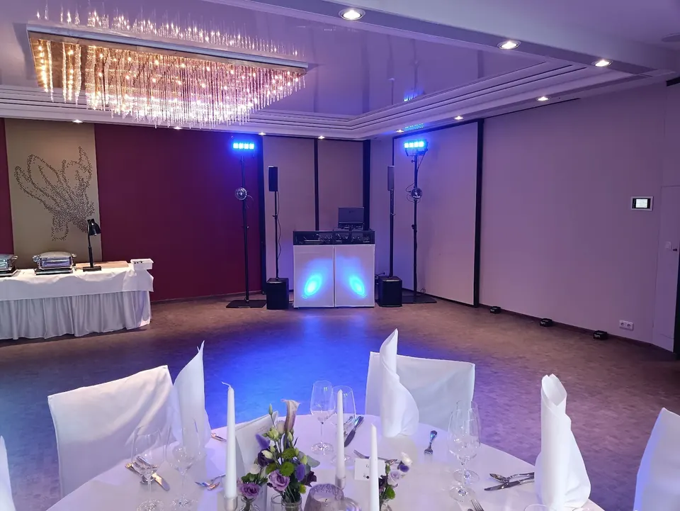 DJ-Pult von Rico Cinsano im Saal des Parkhotels Schmid, davor ein gedeckter Tisch für die Hochzeitsgäste
