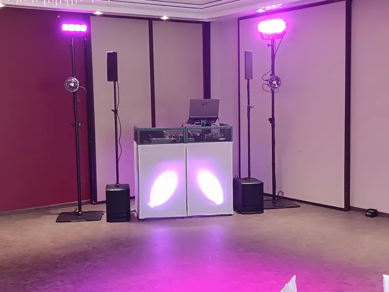 DJ-Pult mit Lautsprechern und Lichtstativen im Saal des Parkhotels Schmid