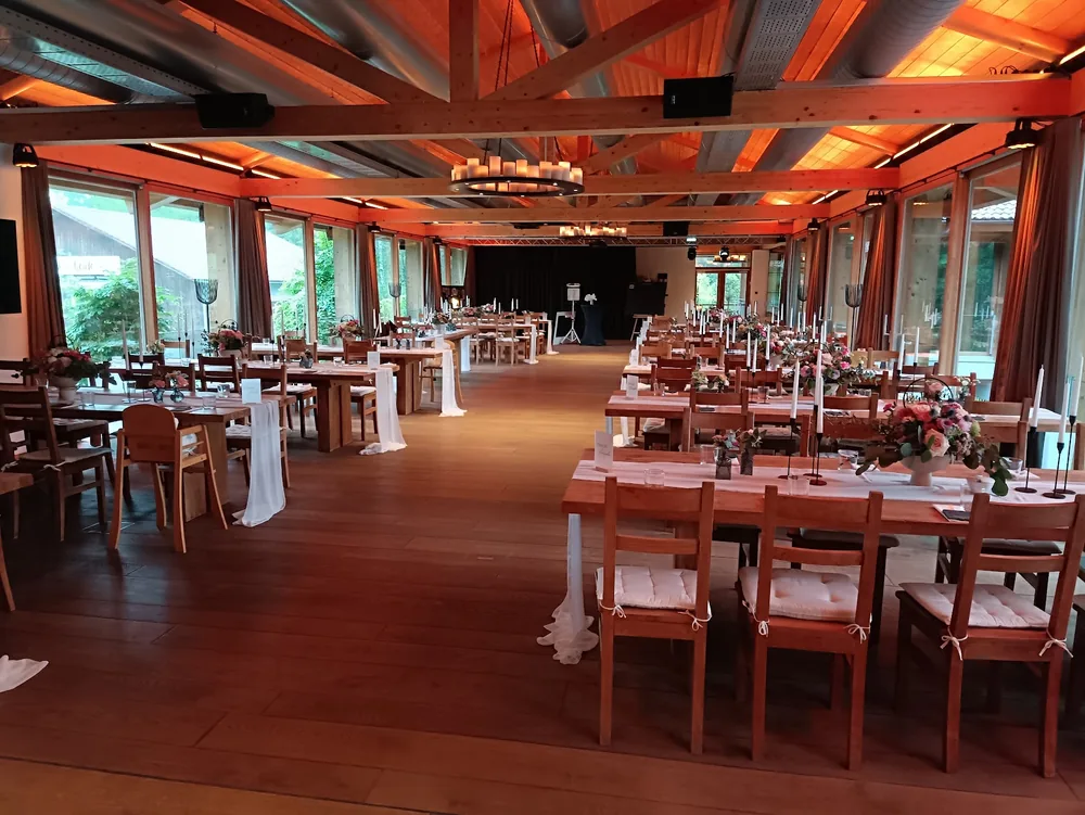 Gedeckte Hochzeitstafel im Saal der Birkenheide mit Kerzenleuchtern und Fensterfront