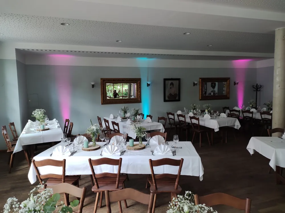 Gedeckte Tafeln im Saal des Landhausbräu Koller mit farbigen Uplights an den Wänden