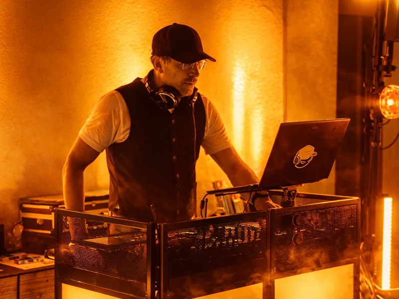 DJ Rico Cinsano am DJ Pult mit warmem Ambientelicht