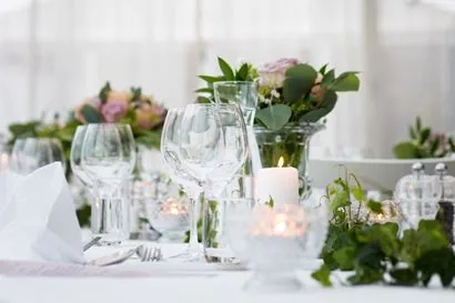Festlich gedeckter Tisch mit Gläsern, Kerzen und Blumen