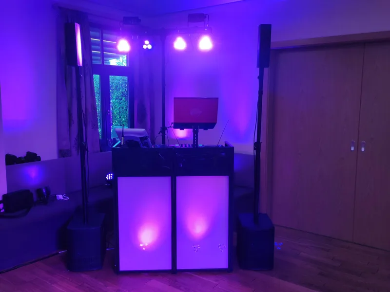 DJ-Setup mit lila und pinkfarbenem Uplighting im Veranstaltungsraum am Abend – Hochzeits-DJ Rico Cinsano