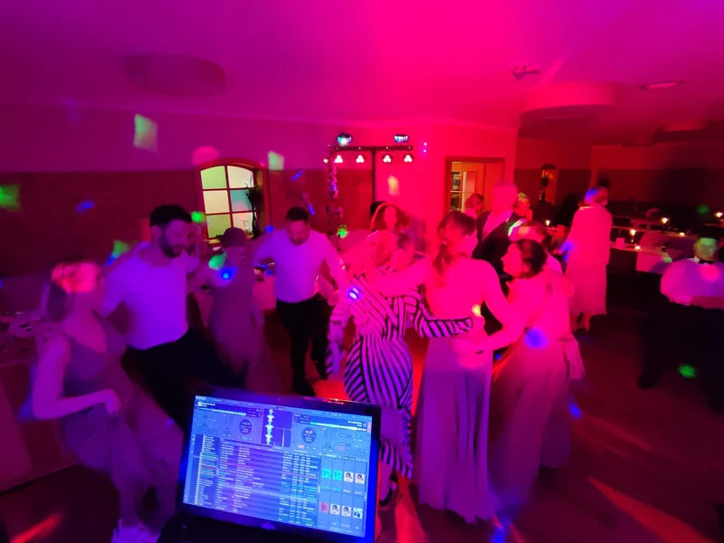 Blick vom DJ-Pult auf vollbesetzte Tanzfläche mit pinkem Licht und tanzenden Gästen – Hochzeits-DJ Rico Cinsano