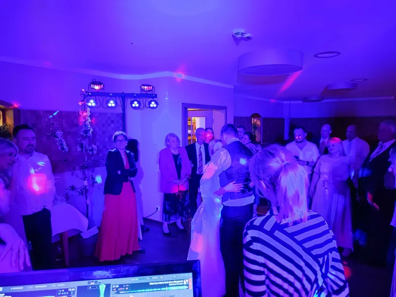Brautpaar tanzt Eröffnungstanz, Gäste schauen zu, lila Stimmungslicht – Hochzeits-DJ Rico Cinsano
