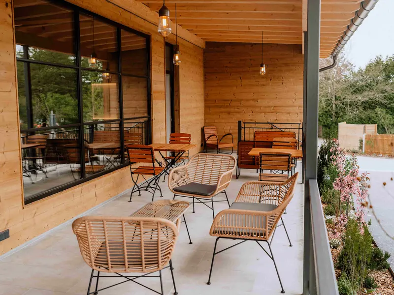 Grafenstadl überdachte Veranda mit Rattanmöbeln, Glühlampen und Blick auf den Garten