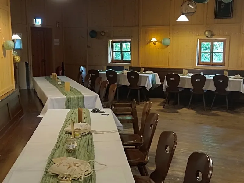 Hochzeitstafel im Innenraum der Sonnenkopfhütte mit grünen Tischläufern und Lampions