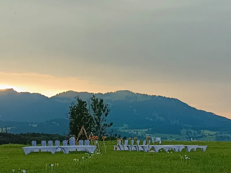 Hochzeitsgesellschaft auf der Almwiese der Sonnenkopfhütte im Sonnenuntergang mit Bergpanorama