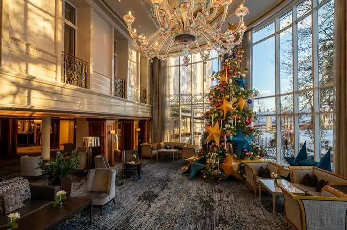 Hotellobby mit großem Weihnachtsbaum und Kronleuchter