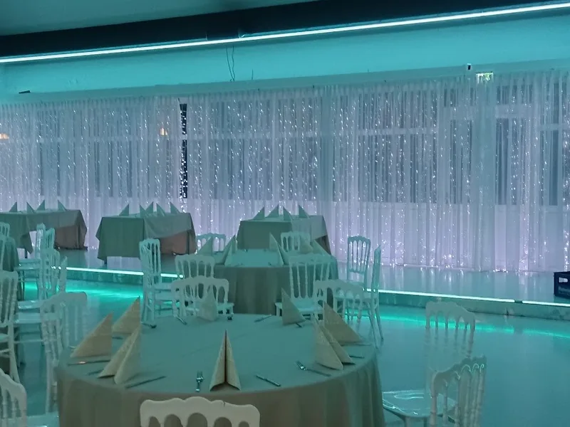 Royal am See Friedberg · Saal mit türkisem LED-Ambientelicht und eingedeckten Tischen