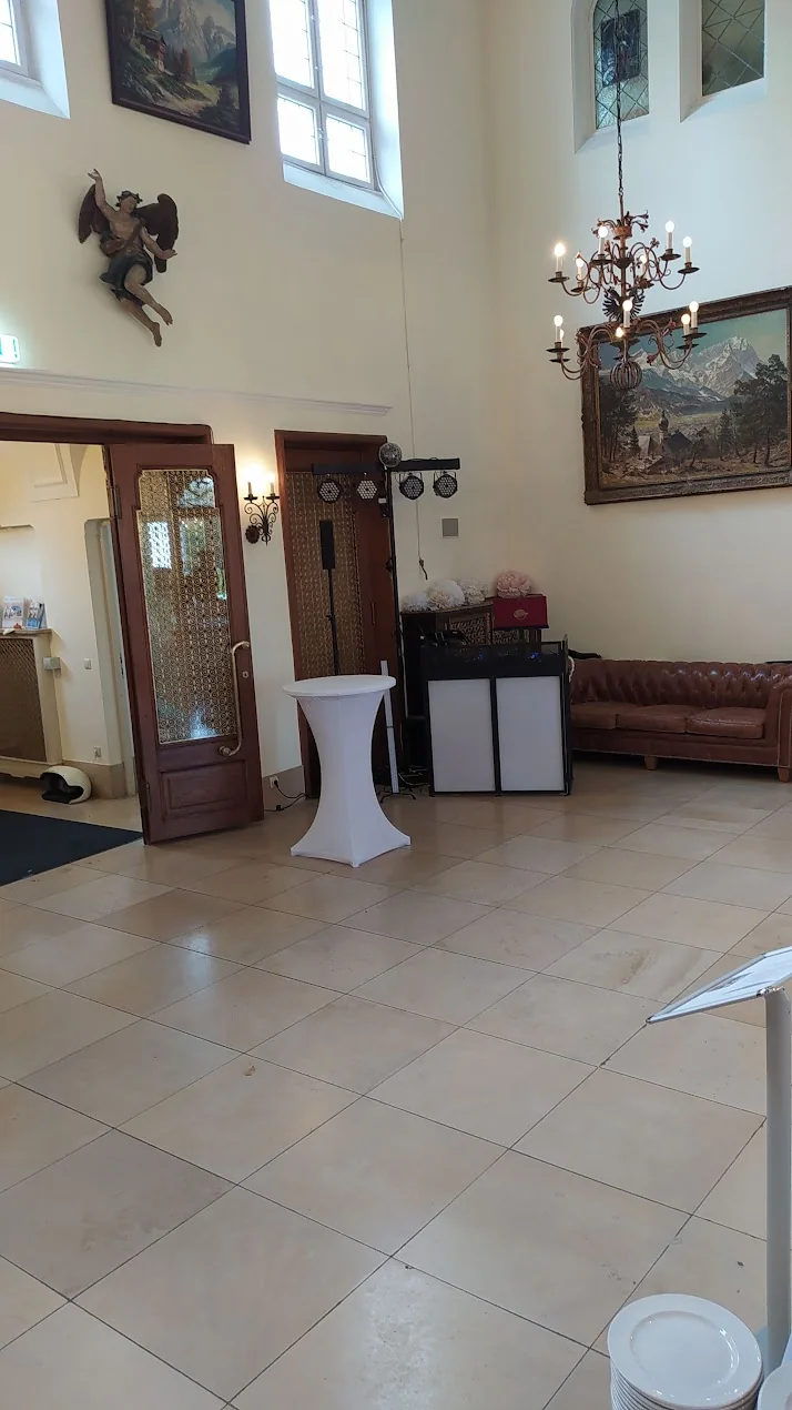 Saal im Schloss Höhenried mit Stehtisch, Kronleuchter und aufgebauter DJ-Technik