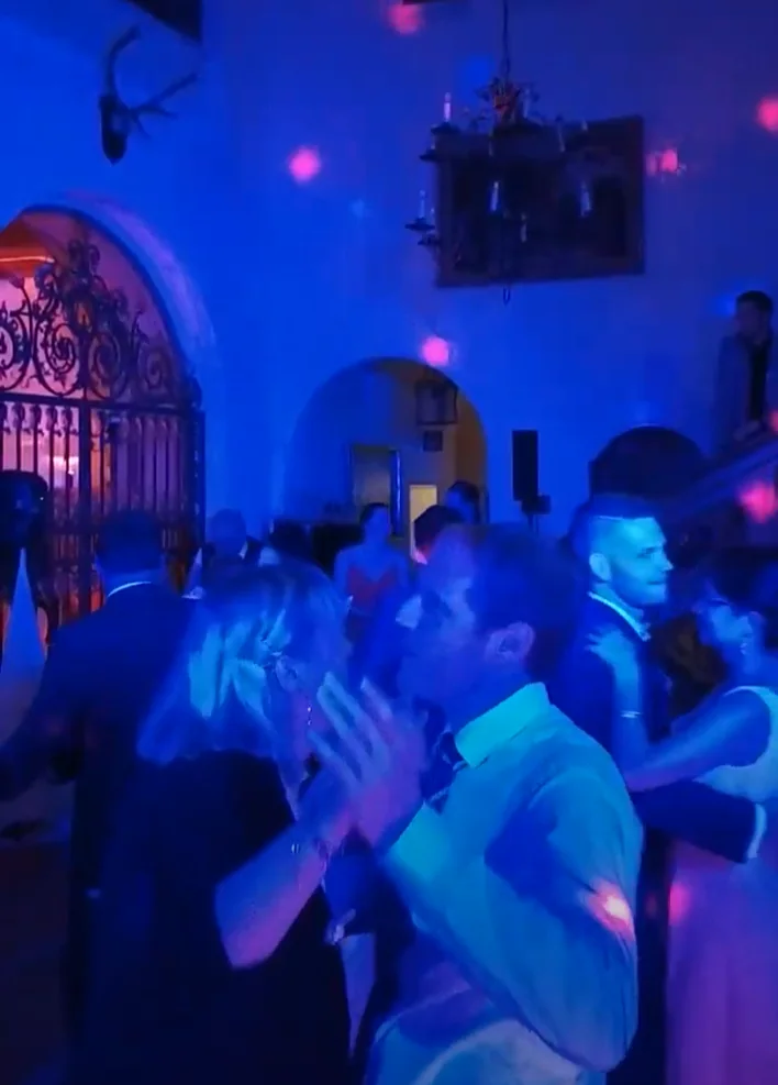 Tanzfläche im blauen Licht im Schloss Höhenried, im Hintergrund das schmiedeeiserne Gittertor