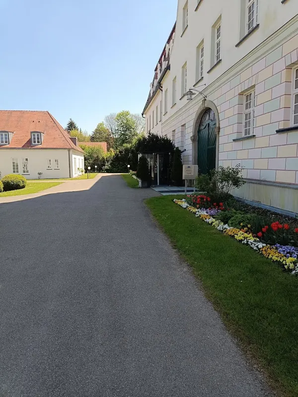 Anfahrt zum Schloss Lautrach mit Hauptportal und blühenden Tulpen