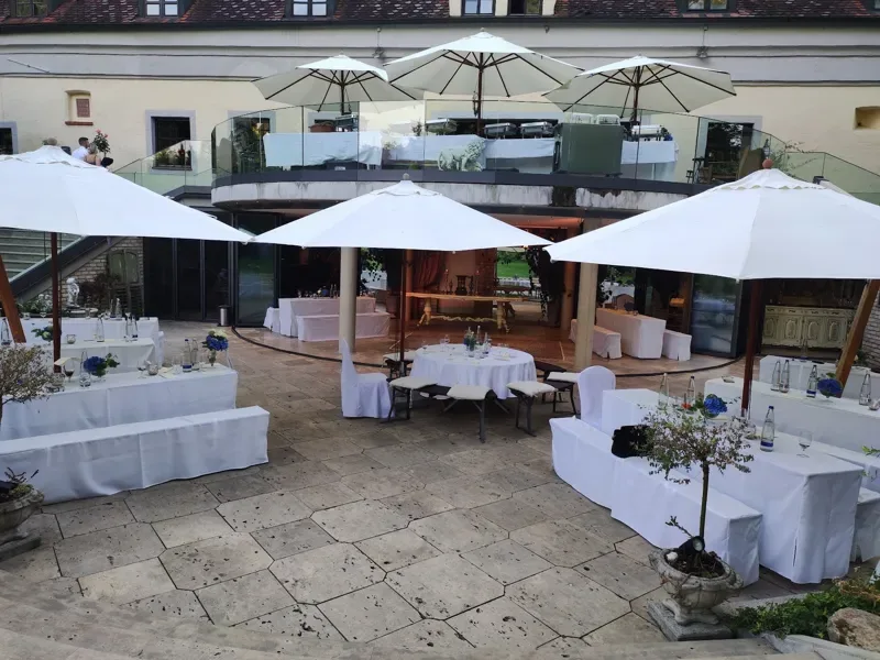 Schloss Oberndorf Terrasse – Sektempfang im Innenhof mit weißen Tischen