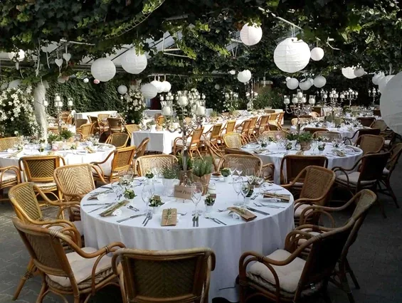 Wintergarten mit runden Tischen und weißen Lampions